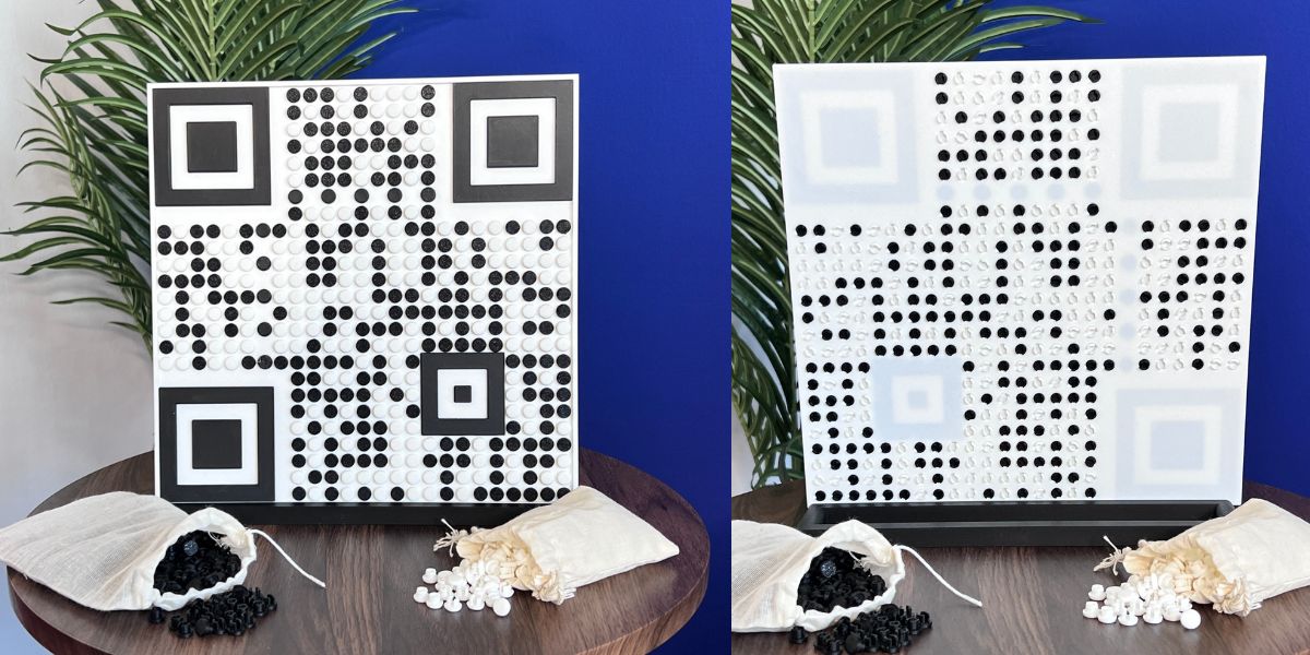 Completed QR code board on its stand, with bags of black and white pixel dots